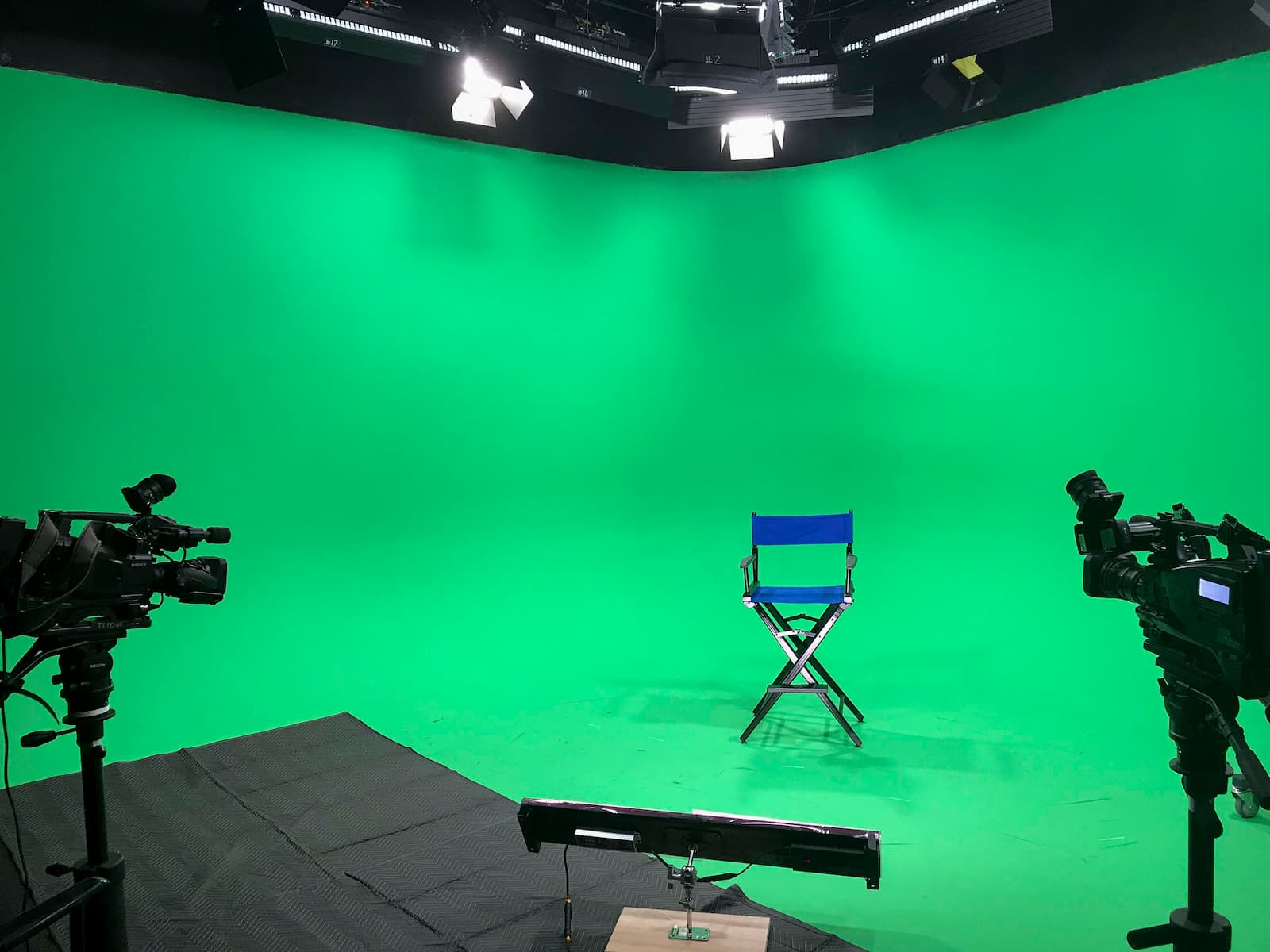 Photo of a director's chair in the middle of our TV stage with camera equipment on both sides